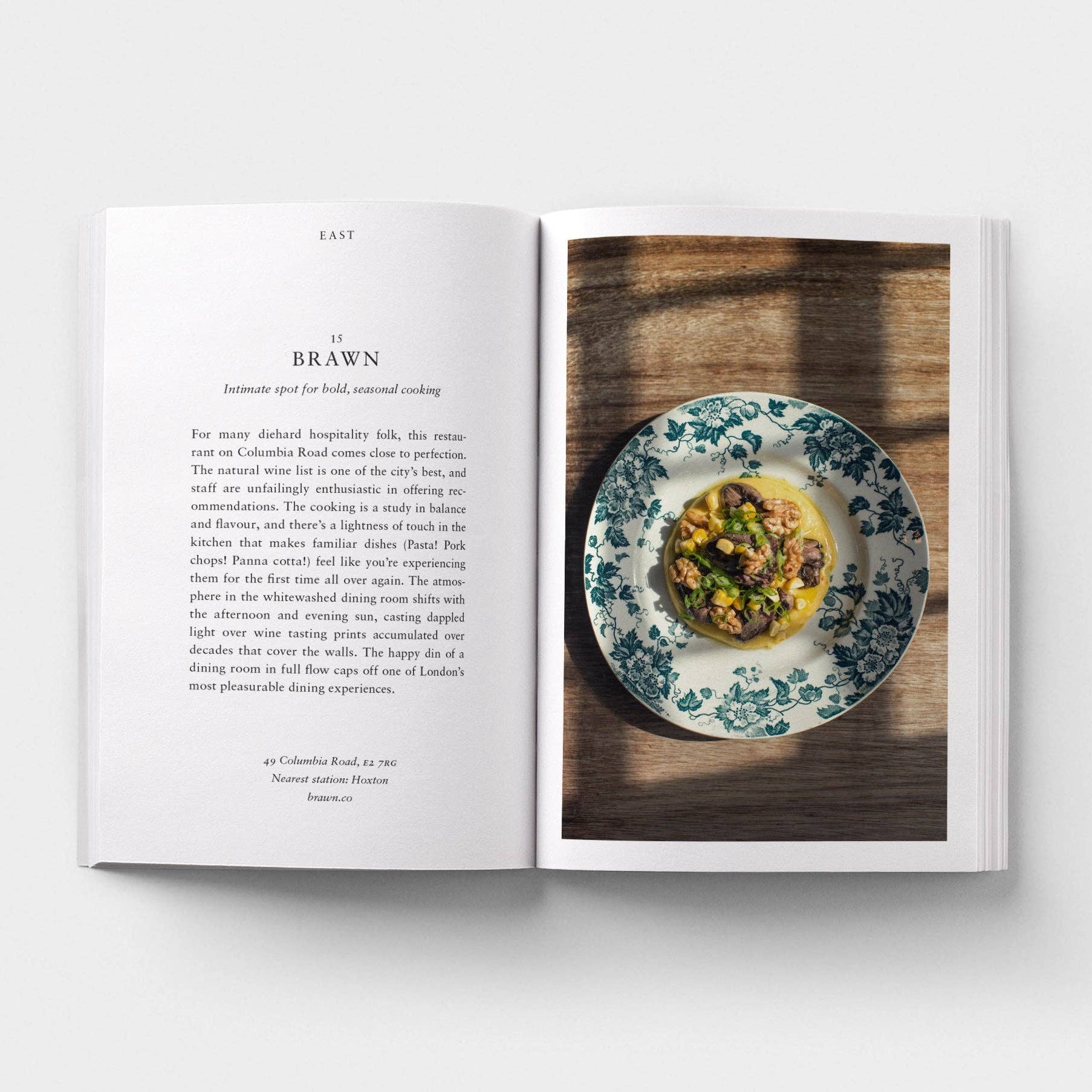 Open book showing a plate of food on a wooden table
