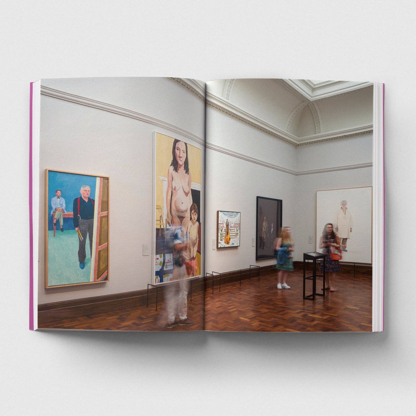 Open book showing a gallery interior with art on the walls and people observing.