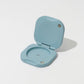 Light blue plastic device with a hinged lid on a white background