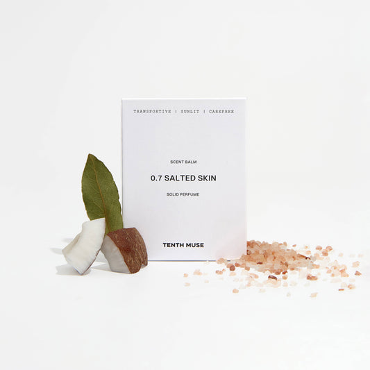 Perfume bottle labeled '0.7 Salted Skin' by Tenth Muse with a small plant and salt crystals on a white background.