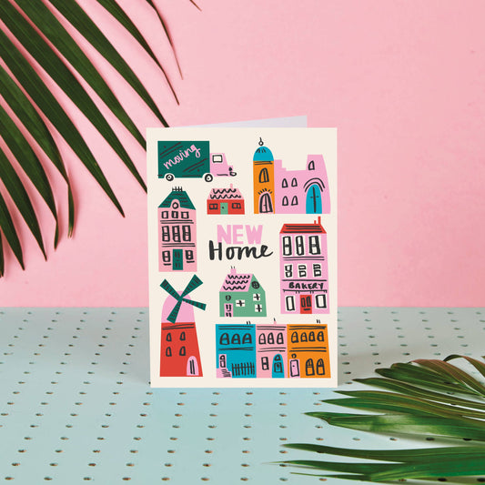 Greeting card with colorful house illustrations on a pink background