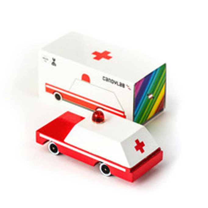 Toy ambulance with a rainbow-colored box on a white background
