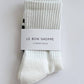 Pair of white socks with a label on a light gray background