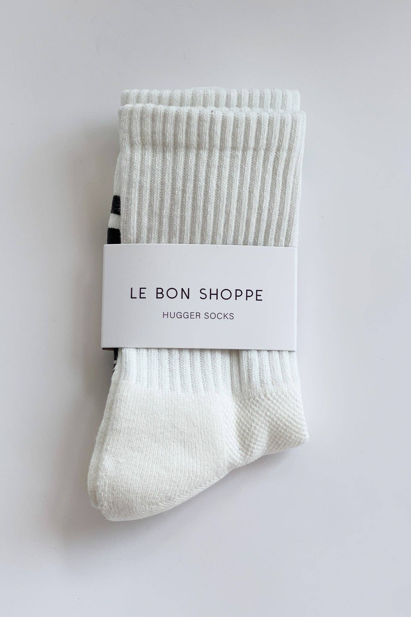 Pair of white socks with a label on a light gray background
