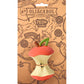 Oli & Carol dog toy packaging with a red and white apple-shaped toy on a brown background.