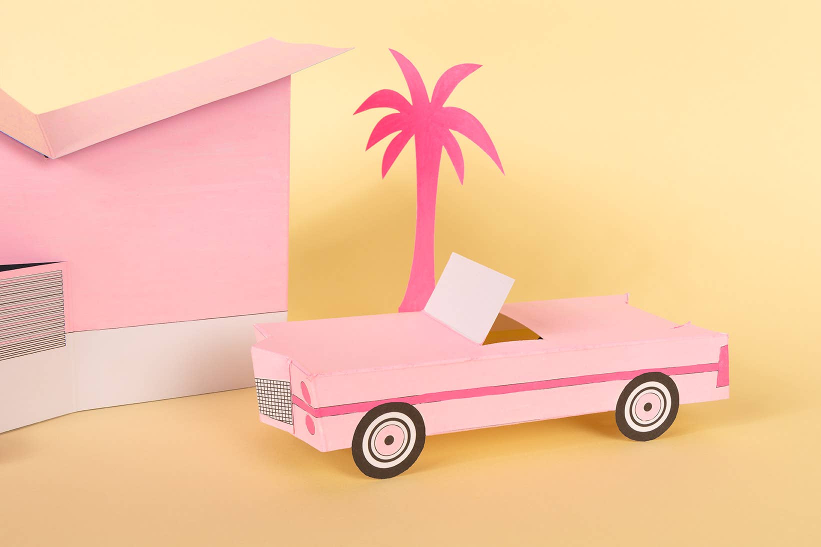 Pink toy car with a palm tree on a yellow background