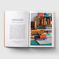 Open book showing text and a photograph of a workspace with books and materials.