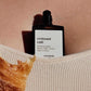 Perfume bottle labeled 'croissant cafe' by versatilie against a blurred background