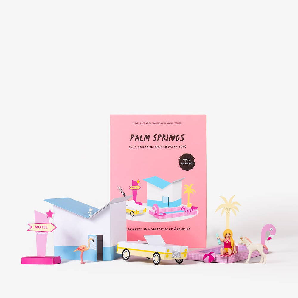 Pink book titled 'Palm Springs' with miniature models on a white background