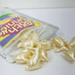 Packaged snacks with white bunny shaped bath pearls on a white background
