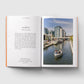 Open book with text on the left and a photograph of a canal scene with a boat on the right.