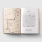 Open book with a map on one page and text on the other, on a light gray background