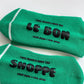 Two green socks with black text on a white background