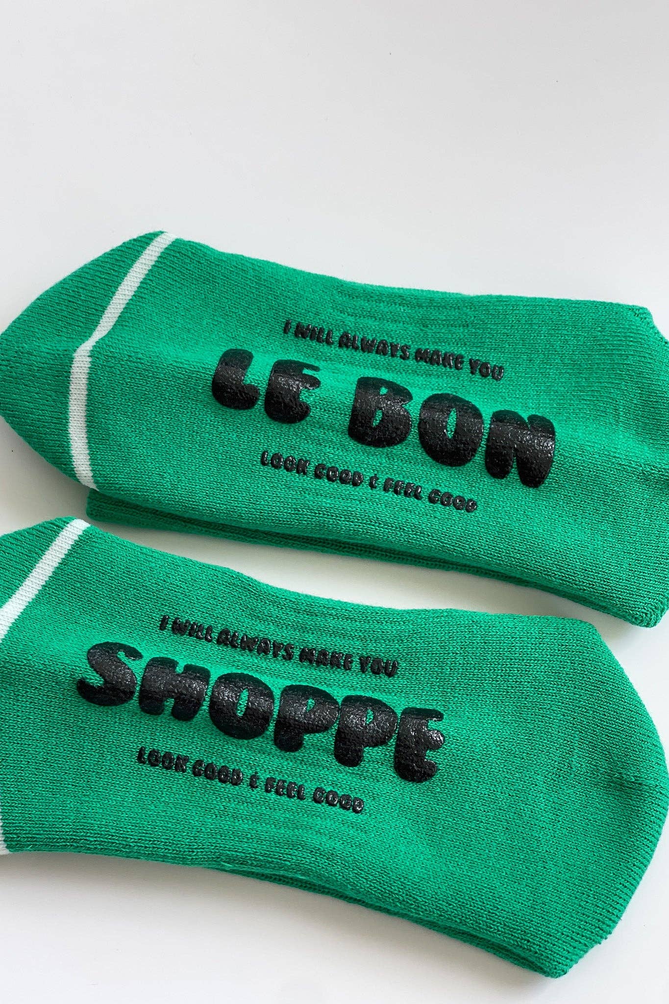 Two green socks with black text on a white background