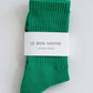 Green socks with a white label on a light gray background