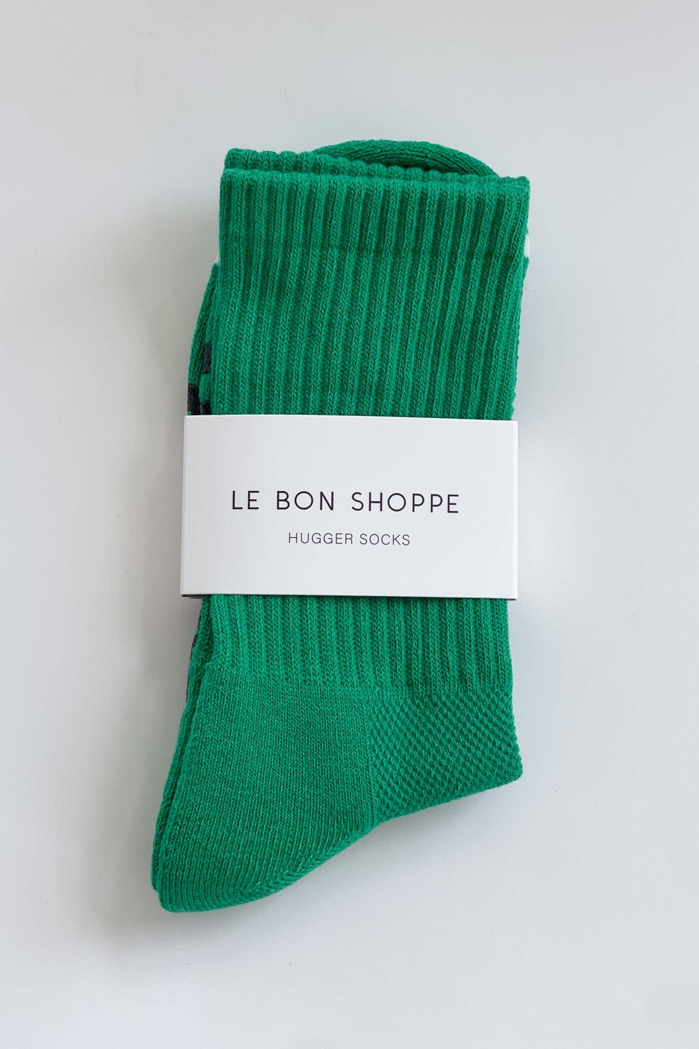 Green socks with a white label on a light gray background