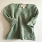 Green knitted sweater on a white background