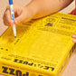 Person holding a yellow puzzle box with a pen, likely solving a crossword puzzle.