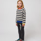 A side angle of the striped jumper outfit, emphasizing the trousers' relaxed silhouette.