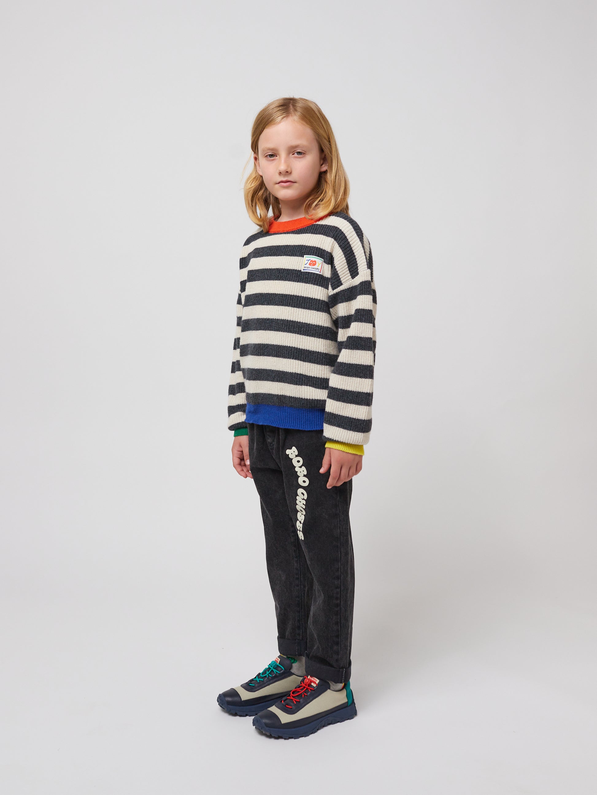 A side angle of the striped jumper outfit, emphasizing the trousers' relaxed silhouette.