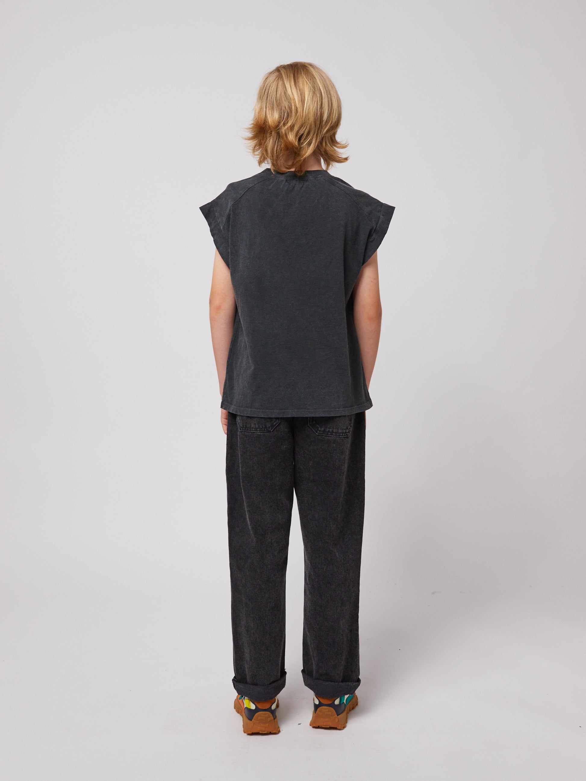 A back view of the model, showcasing the relaxed silhouette of the trousers with two patch pockets.