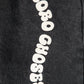 A detailed view of the white "Bobo Choses" lettering on the left leg, contrasting against the black denim fabric.