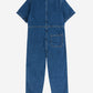 A children's short-sleeved denim jumpsuit laid flat with the back side facing up. It is made from dark blue denim with a structured collar and visible stitching details. A single square patch pocket is positioned on the right side of the lower back. The jumpsuit has a relaxed fit with slightly tapered legs.