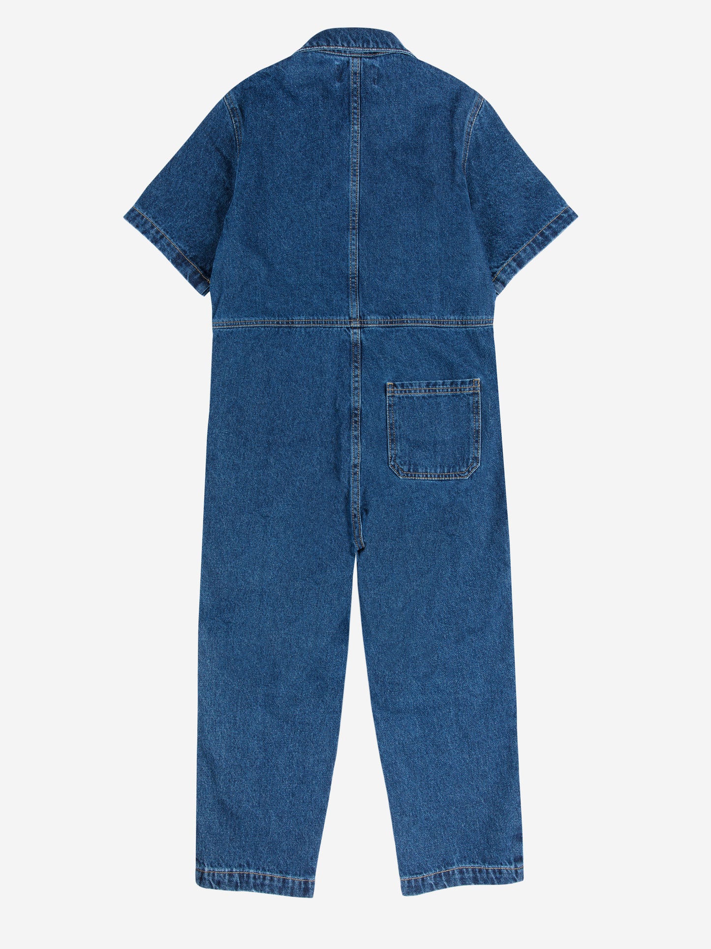 A children's short-sleeved denim jumpsuit laid flat with the back side facing up. It is made from dark blue denim with a structured collar and visible stitching details. A single square patch pocket is positioned on the right side of the lower back. The jumpsuit has a relaxed fit with slightly tapered legs.