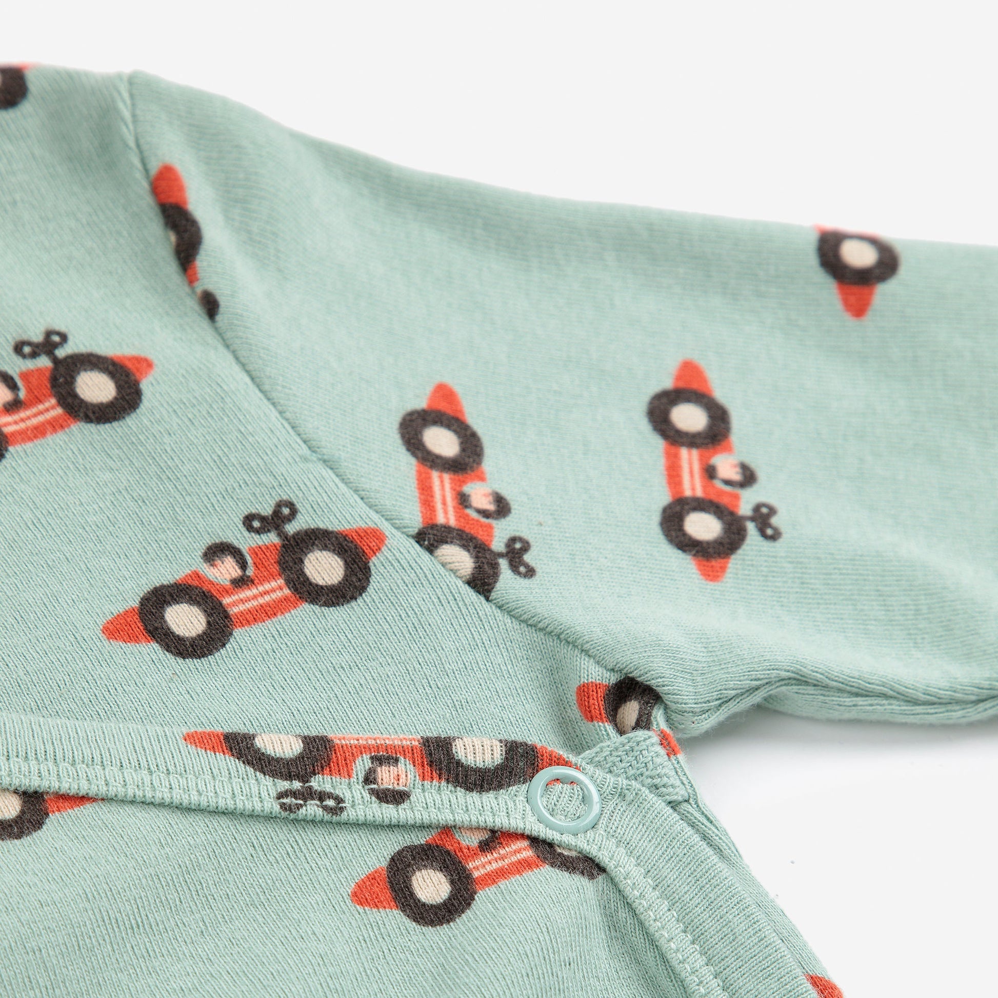 Light green fabric with red and blackrace car pattern on a white background