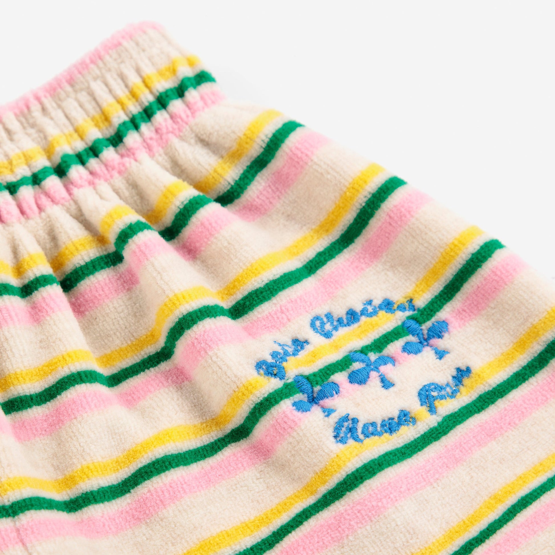 Close-up of a striped fabric with colorful patterns and text on a white background