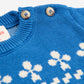 Blue knitted sweater with white snowflake pattern on a white background