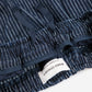 Close-up of a blue denim fabric with a brand label on a white background