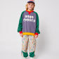Child wearing a colorful outfit with 'Bobo Choses' branding on a white background