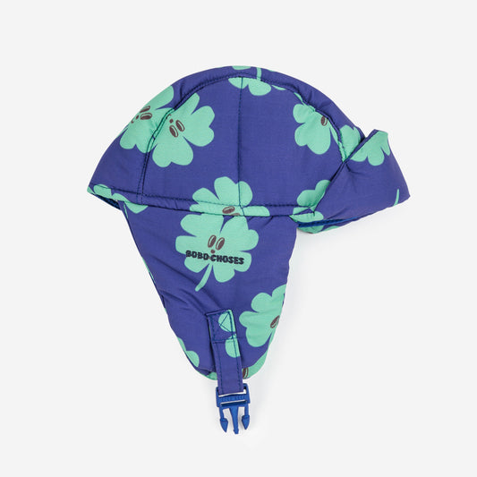 Blue baby hat with green clover patterns on a white background