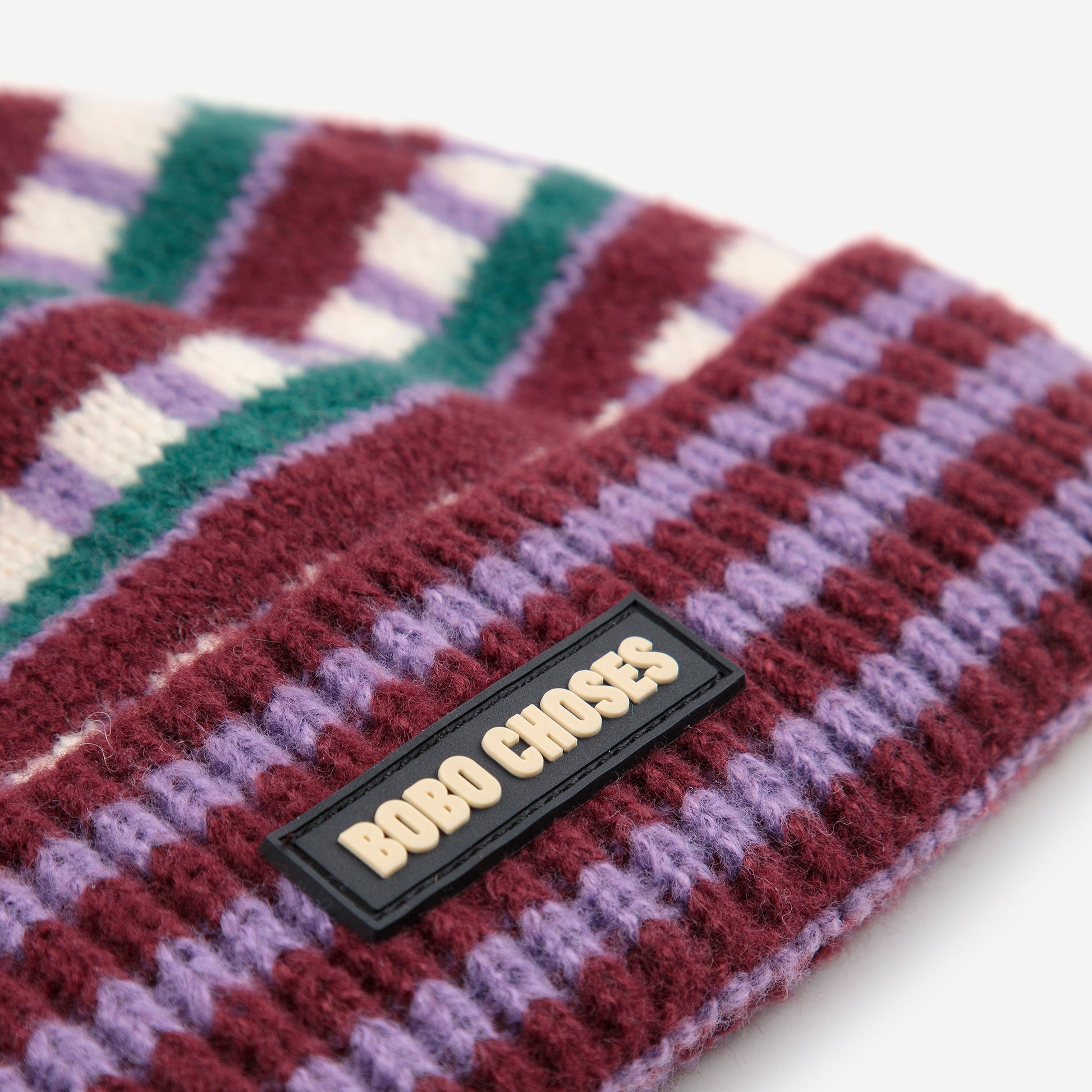 Colorful knitted headband with a brand label on a white background