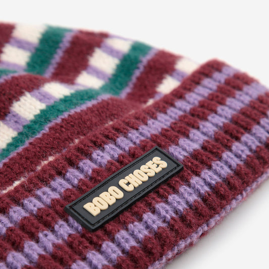 Colorful knitted headband with a brand label on a white background