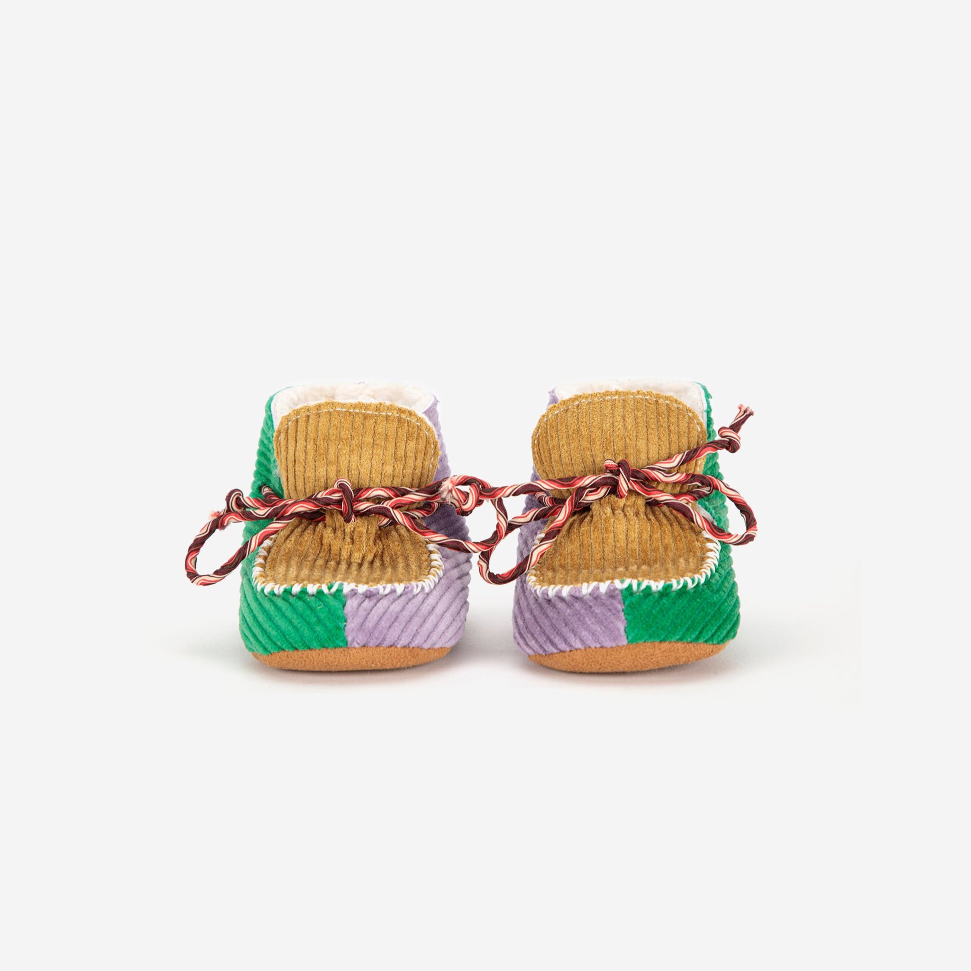 Pair of woven baby shoes with colorful patterns on a white background