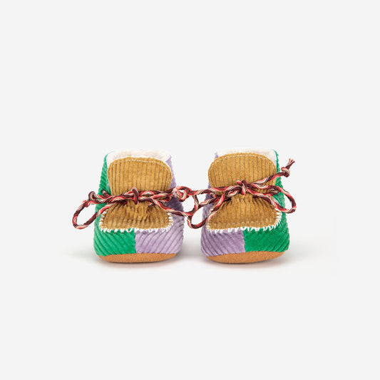 Pair of woven baby shoes with colorful patterns on a white background