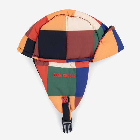 Multicolored patchwork helmet with a visible brand logo on a white background