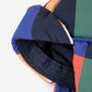 Colorful quilted jacket with geometric pattern on a white background