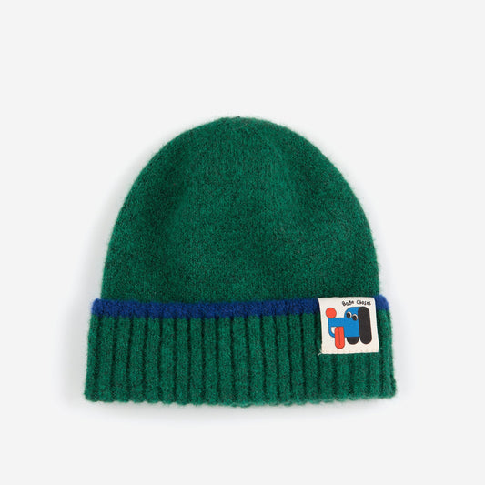 Green beanie with a blue stripe and a logo on a white background