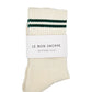 Pair of cream socks with green stripes and a white label on a white background