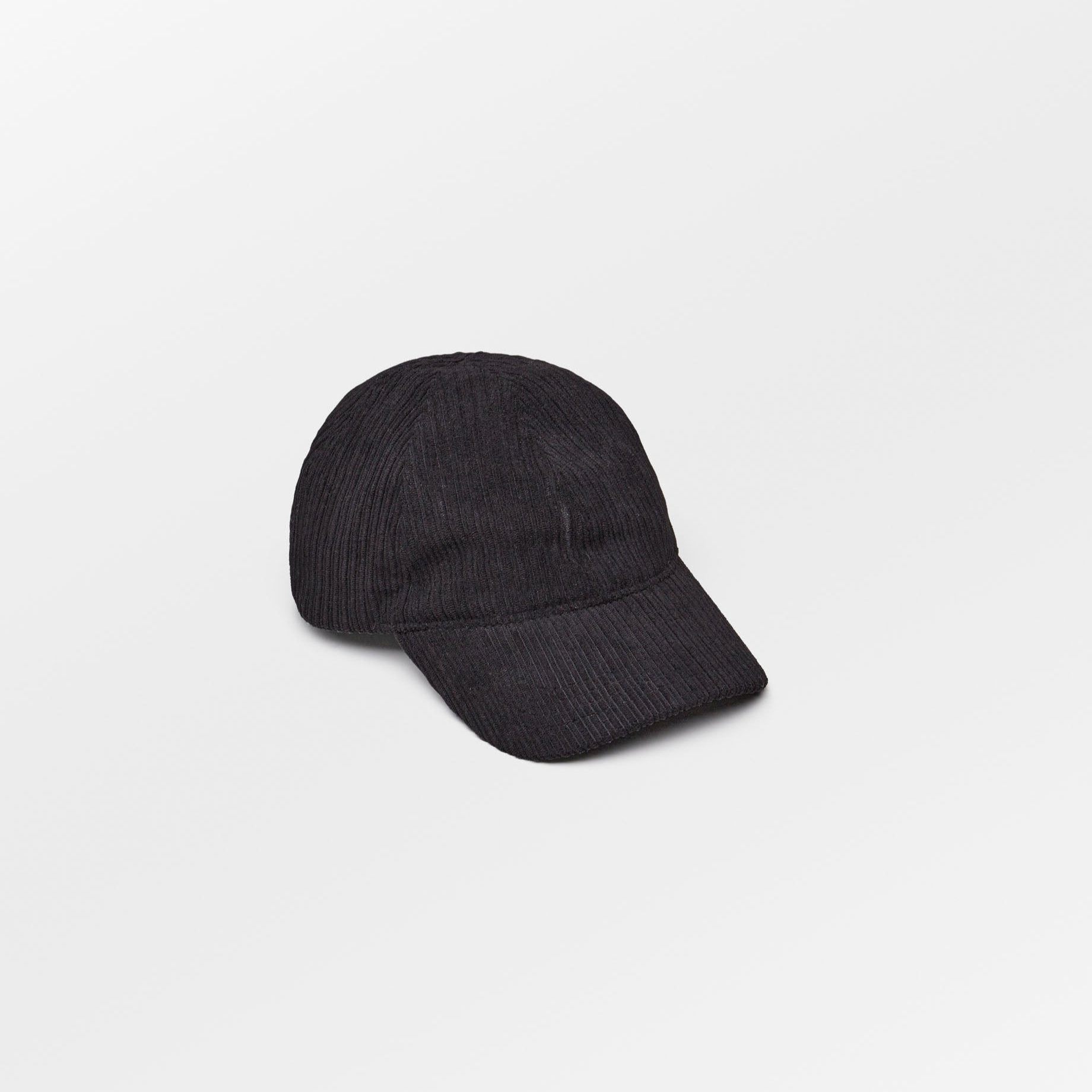 Becksöndergaard Malvi Cap in Black, made from ribbed velvet corduroy, featuring an adjustable strap and a discreet logo at the back. The cap is displayed on a neutral background, highlighting its timeless design and unisex appeal.