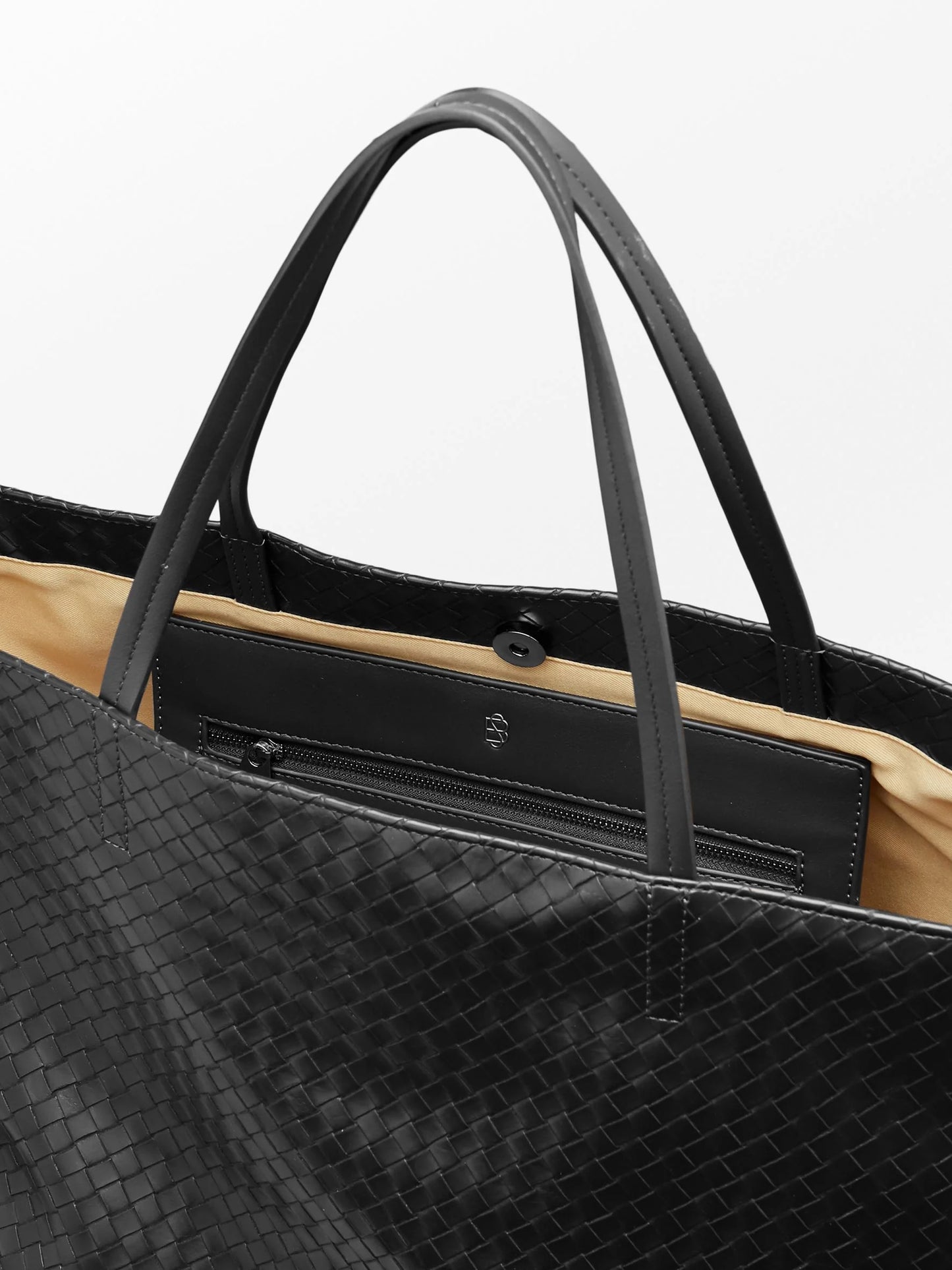 A close up of the interior of Becksöndergaard Rallo Lottie Bag, a spacious and stylish bag designed to hold a 13" laptop, featuring a magnetic closure, large main compartment, and zipped pocket, 