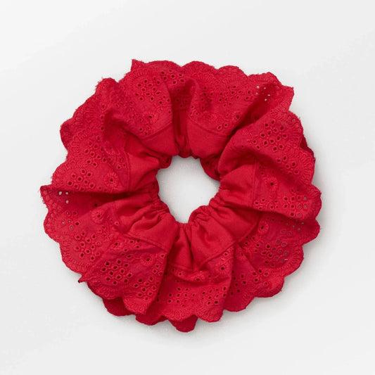 Becksöndergaard Red Musa Anglaise Scrunchie in a vibrant red hue with delicate broderie anglaise detailing, showcasing its soft, textured fabric and gathered elastic design for a stylish and comfortable fit.