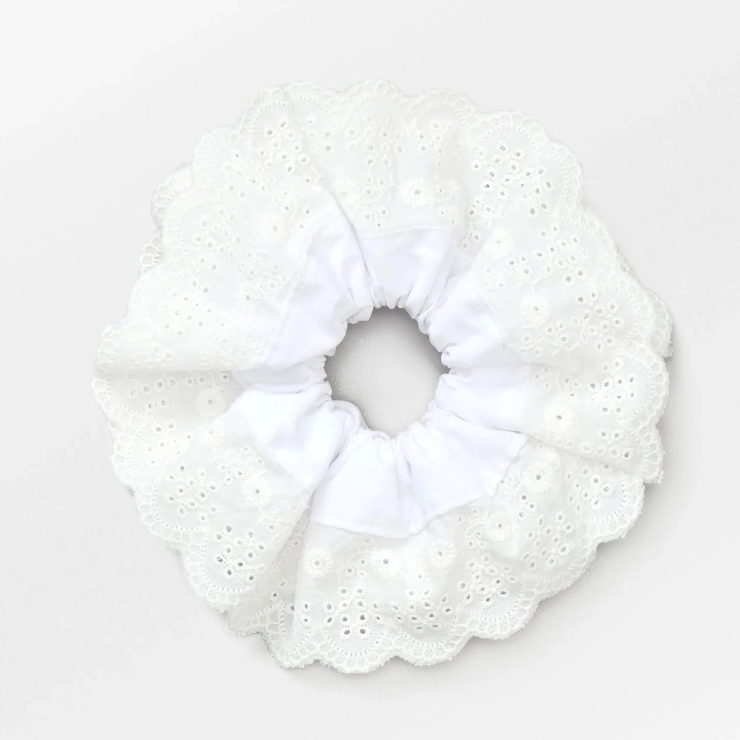 Becksöndergaard White Musa Anglaise Scrunchie featuring a lace-like design, adding a delicate and feminine touch to hairstyles with its soft fabric and gathered elastic.