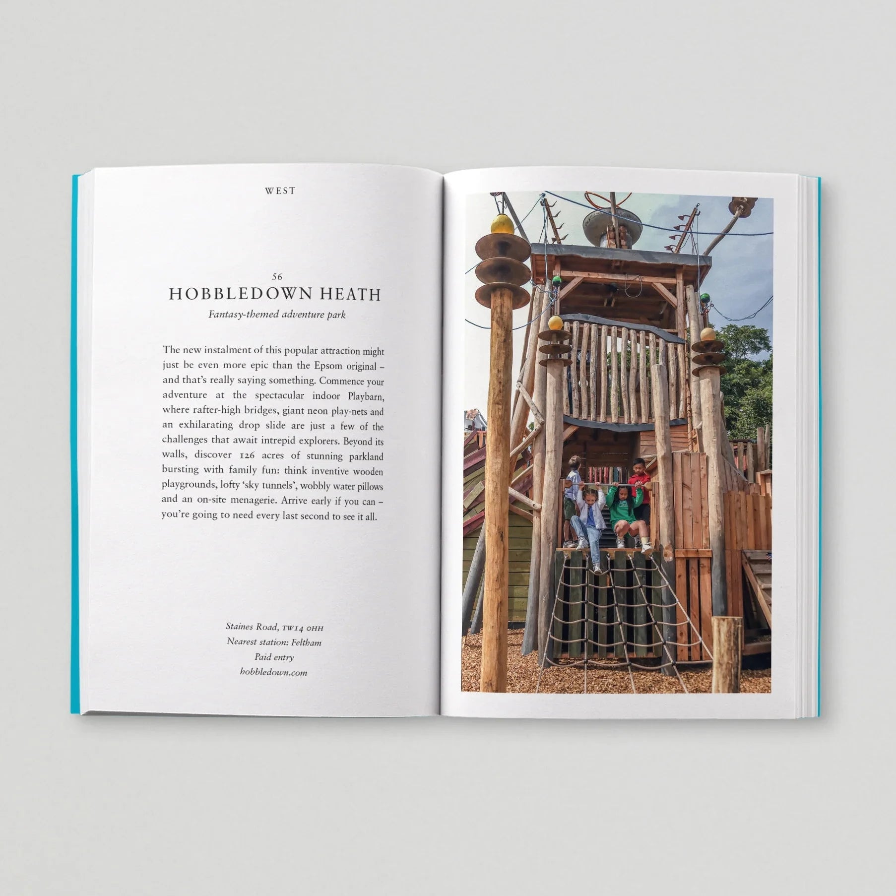 Open book showing text and a photograph of a playground structure.