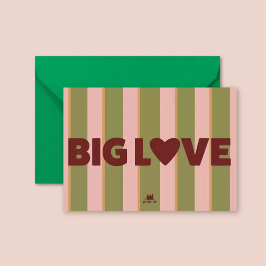 A greeting postcard with bold, retro-style typography reading "BIG LOVE" in deep red, with a heart symbol replacing the "O". The background features vertical pink and olive-green stripes. The card is paired with a bright green envelope.