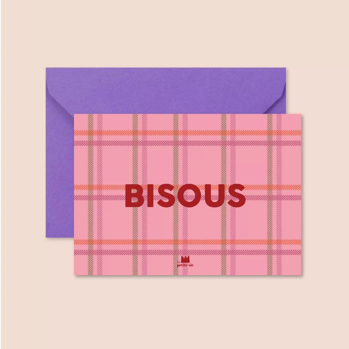 A postcard with a pink tartan background featuring bold red text in the centre that reads "BISOUS." The design is paired with a deep purple envelope.