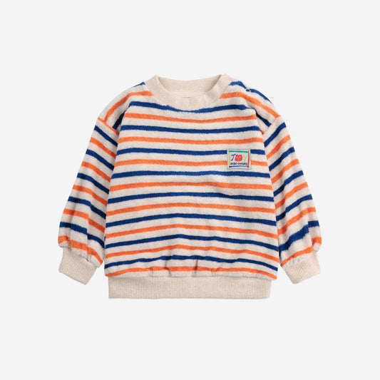 A Bobo Choses baby terry cloth sweatshirt with horizontal stripes in orange, blue, and cream. The sweatshirt features a ribbed neckline, cuffs, and hem, along with a small "JOY Bobo Choses" patch on the chest.